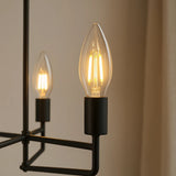 Dulora 4.2W Candle LED Bulb E14 Clear in Warm White glowing in a black modern candelabra pendant