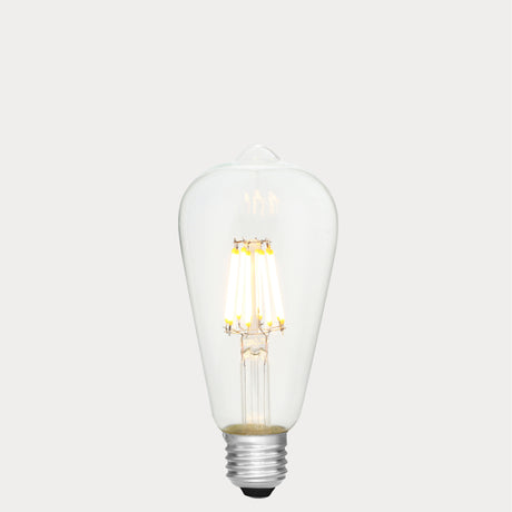 Dulora 8W E27 LED Edison-style bulb in clear glass with AC/DC compatibility, glowing with 2700K warm white light.